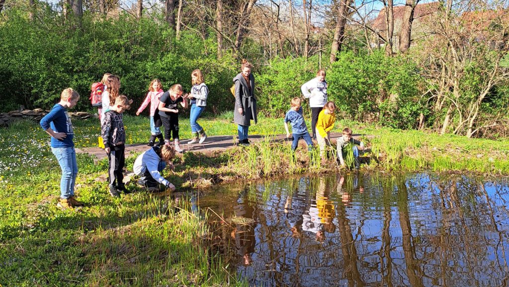 Kinder am Rande eines Teiches